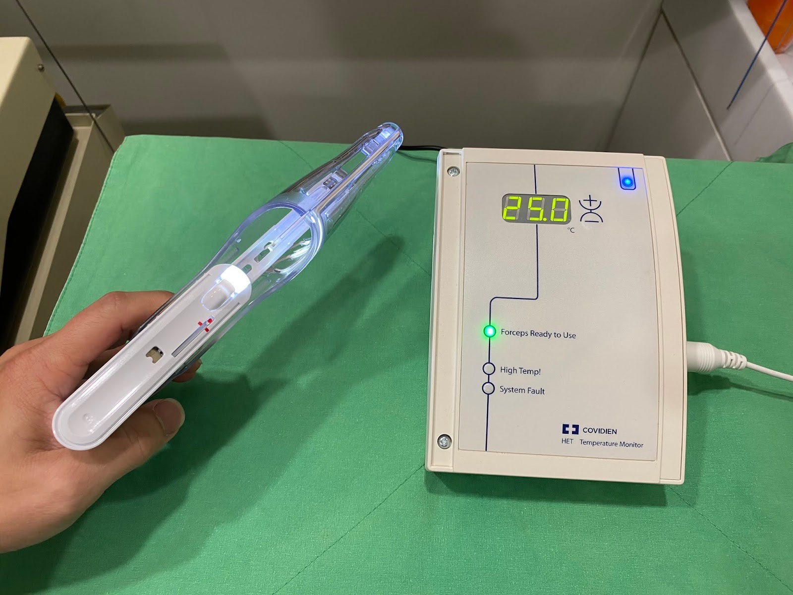 手持冷凝手術器械，旁為顯示溫度的主機