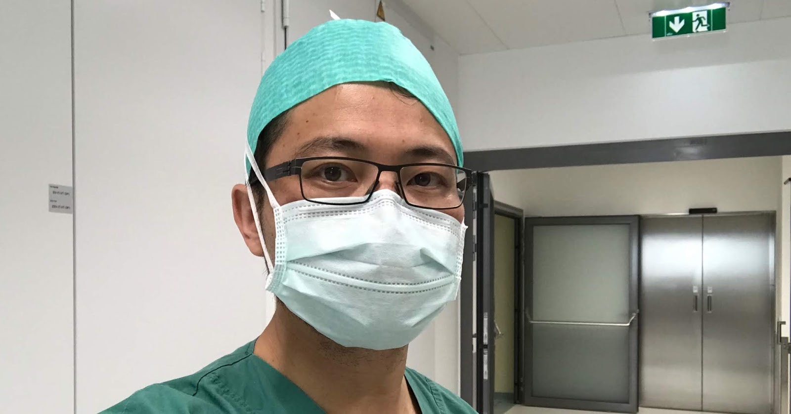 林耿億醫師穿手術服戴口罩,在醫院走廊自拍
